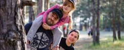 A joyful family enjoying a playful day in a sunlit forest park, capturing the essence of togetherness.